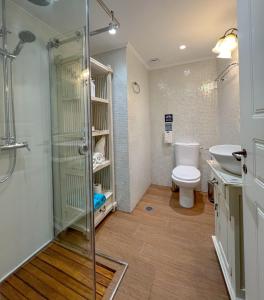 a bathroom with a shower and a toilet and a sink at PortaDelMare deluxe suites in Hydra