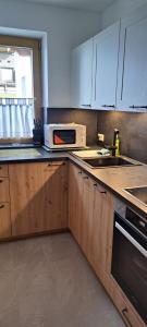 a kitchen with a microwave and a sink at Ferienwohnungen Windegg in Tulfes