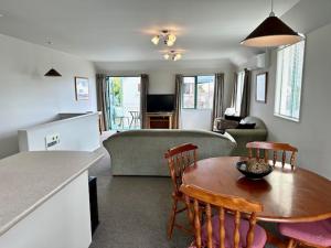 ein Wohnzimmer mit einem Tisch und einem Sofa in der Unterkunft Les Troupes Apartments in Akaroa