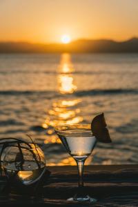 een drankje en zonnebril op het strand bij zonsondergang bij Parada Beach Camp in El Nido
