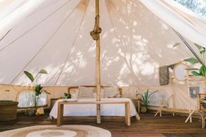 namiot z łóżkiem i stołem w obiekcie Parada Beach Camp w mieście El Nido