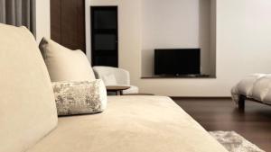 a living room with a bed and a television at Villa Hilala Miyakojima in Miyako Island