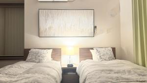 two beds sitting next to each other in a bedroom at Villa Hilala Miyakojima in Miyako-jima
