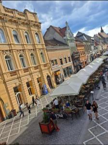 a group of people walking around a street with buildings at City Tales Residence in Braşov