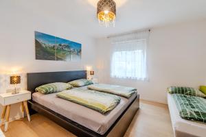 a bedroom with two beds and a window at Apartmaji Hosnar, apartma Lev in Bovec