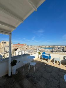a balcony with chairs and a view of a city at San Pietro Otranto in Otranto