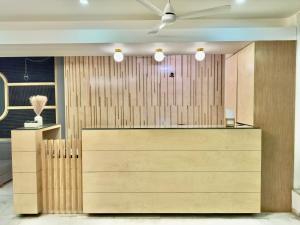 a lobby with a wooden wall with a reception desk at Hotel Volga in Ahmedabad