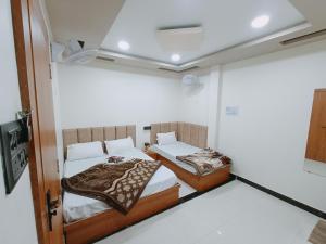 een kamer met 2 bedden in een kamer bij Hotel Shreem in Ujjain
