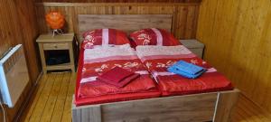 a bed in a wooden room with two pillows at Villa Jare I in Nyíregyháza