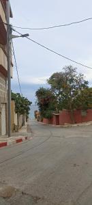 an empty street with trees on the side of the road at Le Bon Coin in 'Aïn el Turk