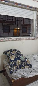 a bed with a pillow in a window at Le Bon Coin in 'Aïn el Turk