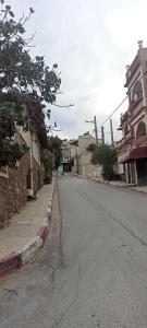una calle vacía en una ciudad con edificios en Le Bon Coin, en Aïn El Turk