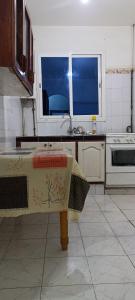 cocina con mesa, fregadero y ventana en Le Bon Coin, en Aïn El Turk