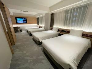 a hotel room with three beds and a flat screen tv at Henn na Hotel Nara in Nara +37 photos
