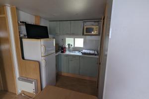 eine kleine Küche mit Kühlschrank und Spüle in der Unterkunft Charming cottage in La Tranche-sur-Mer in La Tranche-sur-Mer