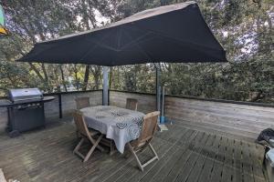 einen Tisch und Stühle unter einem Schirm auf einer Terrasse in der Unterkunft Charming cottage in La Tranche-sur-Mer in La Tranche-sur-Mer