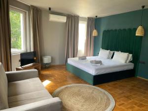 The LODGE Summer Apartments Sozopol في سوزوبول: غرفة نوم بسرير كبير وأريكة