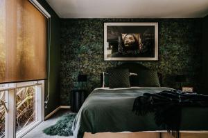 a bedroom with a bed with green wallpaper at Boatshed Villa Yellow Door in Daylesford