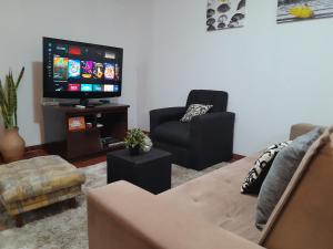 a living room with a couch and a tv at OBhouse Apartment, para sentirse como en casa! in Asunción