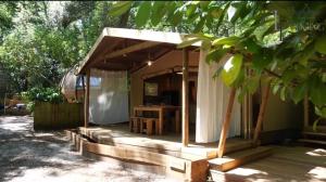 Casa con porche de madera con dosel en Lodging Le Lac en Lacanau