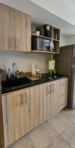 a kitchen with wooden cabinets and a black counter top at ¡Torre Modra Apartamento Moderno Atractiva Zona 4! in Guatemala