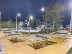 een groep picknicktafels in een park 's nachts bij Apartamento santa marta LE’More in Santa Marta