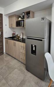 eine Küche mit einem Kühlschrank aus Edelstahl und Holzschränken in der Unterkunft ¡Torre Modra Apartamento Moderno Atractiva Zona 4! in Guatemala