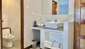 a bathroom with a sink and a toilet at The XIMO Suites in Boracay