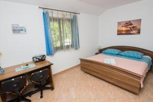1 dormitorio con cama y escritorio en Apartment RB en Omišalj