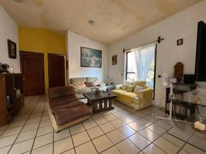 ein Wohnzimmer mit einem Sofa, Stühlen und einem Tisch in der Unterkunft Villa de los abuelos, Burgos Cuernavaca in Temixco