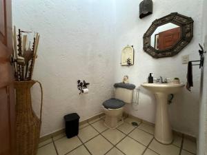 ein Badezimmer mit einem Waschbecken, einem WC und einem Spiegel in der Unterkunft Villa de los abuelos, Burgos Cuernavaca in Temixco