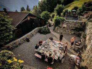 een groep mensen die rond een tafel in een tuin zitten bij Alpine Vacation Home in Schruns