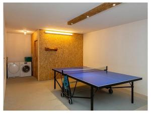 a ping pong table in a room with a washer at Infanglalm "Attersee" in Neukirchen