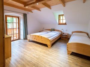two beds in a large room with wooden floors at Infanglalm "Attersee" in Neukirchen