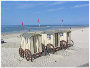 a row of portable shelters on the beach at Old Printing House Holiday Apartment Bodoni in Norderney