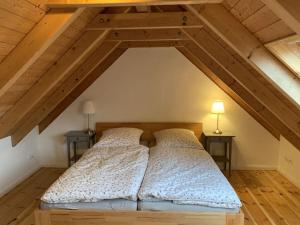 2 letti in una camera mansardata con soffitti in legno di Country house with garden near Greetsiel a Hinte