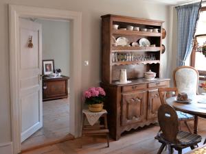 a dining room with a table and a wooden cabinet at Le Prévôt Comfortable holiday residence in Hunawihr