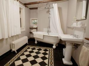 a bathroom with a tub and a sink and a bath tub at Le Prévôt Comfortable holiday residence in Hunawihr