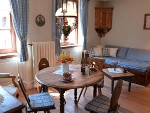 a living room with a table and a couch at Le Prévôt Comfortable holiday residence in Hunawihr