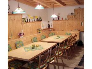 een eetkamer met houten tafels en stoelen bij Holiday apartment 1S oak grove in Lindberg