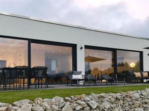 a white house with chairs and tables and windows at FichtelTijd Wellness Sauna Whirlpool in Waldershof