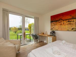 尼維萊特的住宿－Spacious holiday home with garden，一间卧室配有一张床、一张书桌和一个窗户。