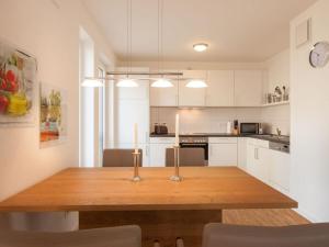 een keuken met een houten tafel met twee kaarsen erop bij Dunes Resort Apartment 1 05 in Binz