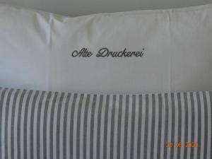 ein weißes Kissen auf einem Bett mit dem Wort "Luftscheidung" in der Unterkunft Old Printing House Holiday Apartment Cicero in Norderney