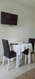 mesa de comedor blanca con 2 sillas y mesa blanca en Pensión San Antón en Sanxenxo