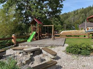 un parque infantil con terraza de madera y columpio en Old toy factory en Český Jiřetín