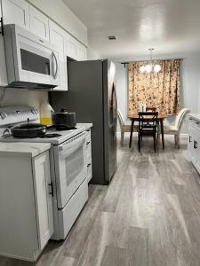 a kitchen with a stove and a microwave and a table at 3Beds Full Kitchen with On Site Parking Close to UC Davis Medical Center in Sacramento