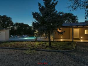 a house with a tree and a swimming pool at Noelene Comfortable holiday residence in Valtura