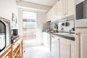 een keuken met witte kasten en een raam bij Victoria Sole & Mare in Menton