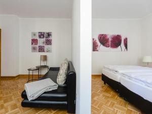 a bedroom with a bed and a black leather couch at Country House Mettenberg in Eslohe